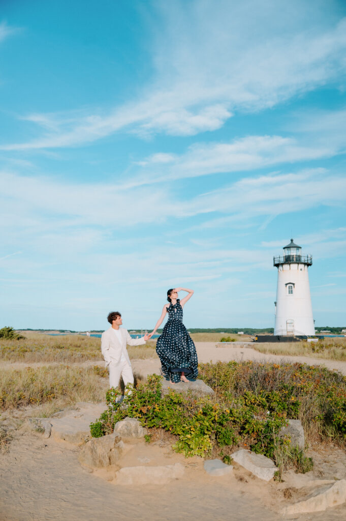 Engaged couple in front of light house